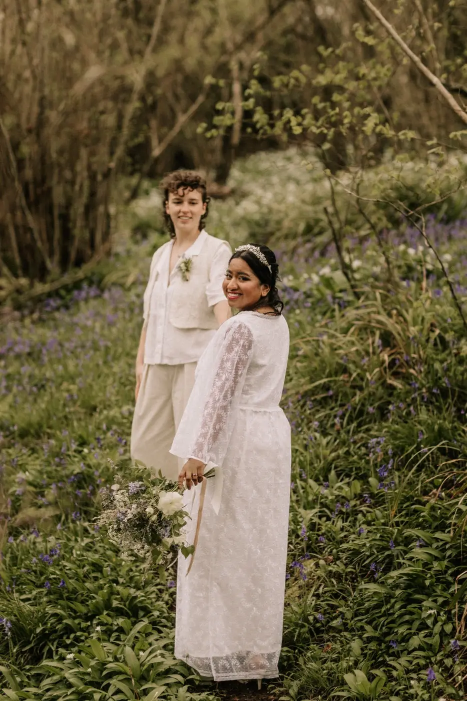 Nadia and Poppy standing together among the bluebells and wild garlic