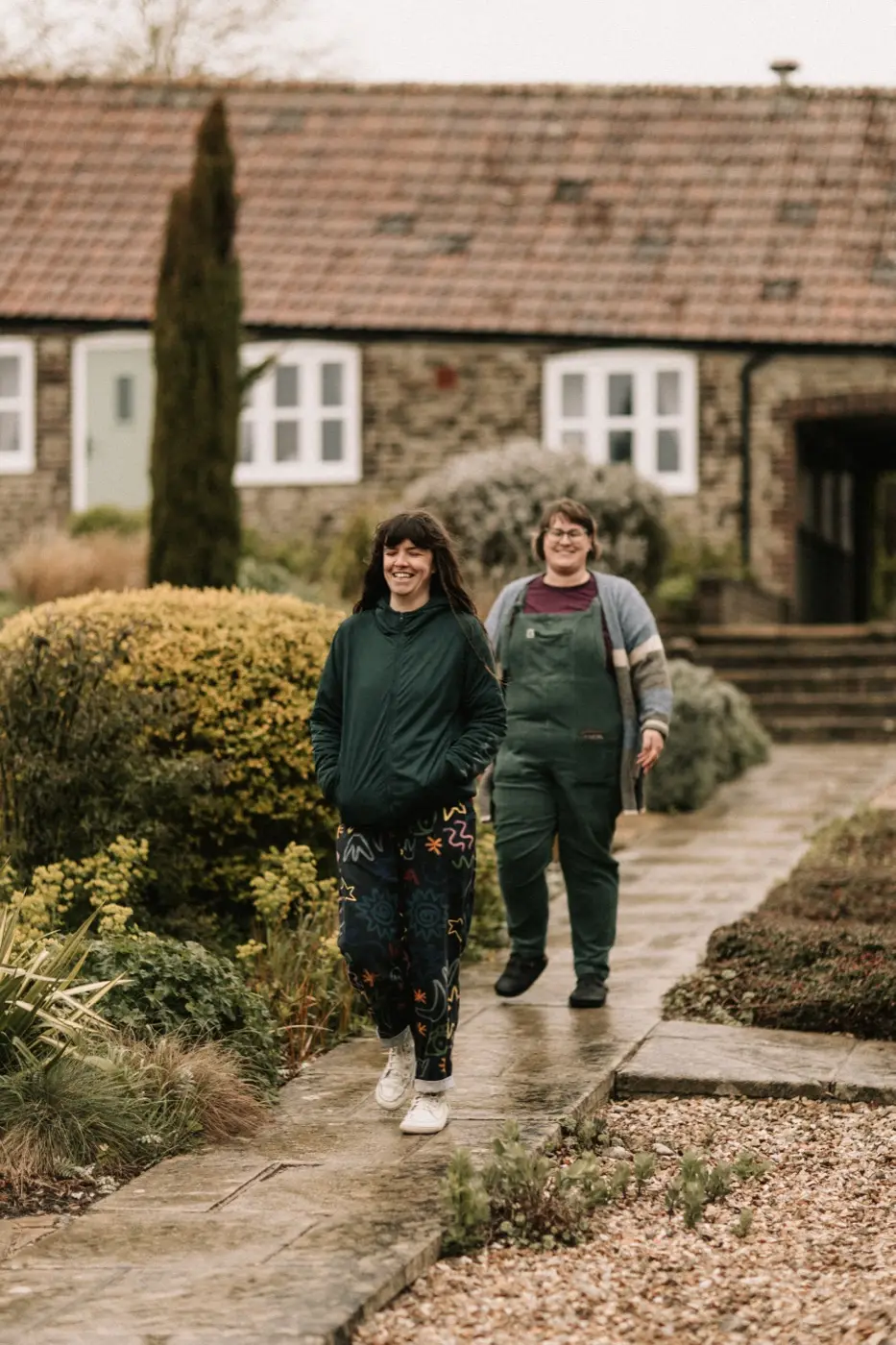 Nadia and Poppy walking together through the cottage gardens at Rudge Farm