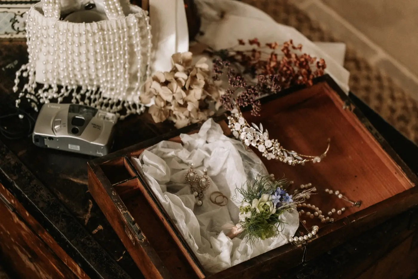 A pearl bag and keepsake box laid out with dried flowers