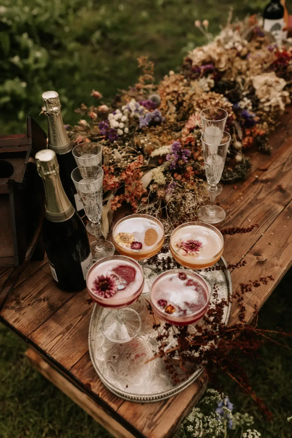 The woodland drinks table dressed with dried flowers, champagne and coloured cocktails
