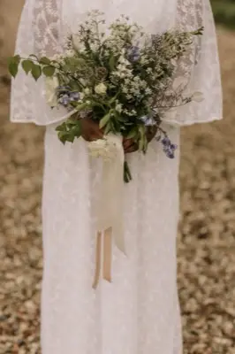 The wild bouquet held against the vintage lace dress