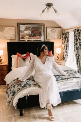 Sitting on the bed in the floral-wallpapered cottage bedroom