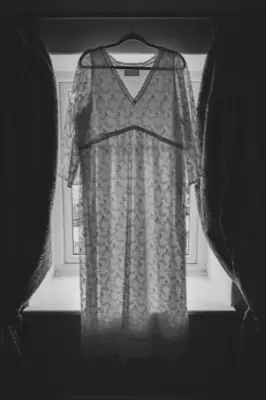 The wedding dress hanging in the cottage window