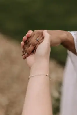 A close-up of Nadia and Poppy holding hands