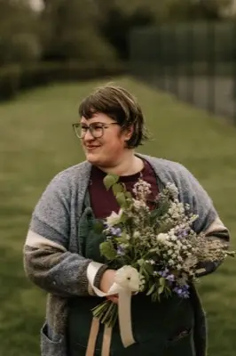 Portrait holding the bouquet in a grey cardigan