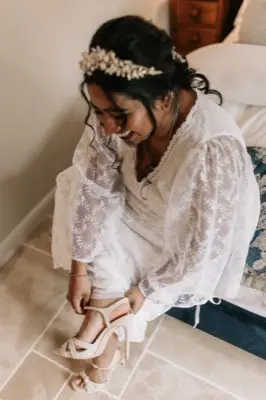 Putting shoes on in the white lace dress